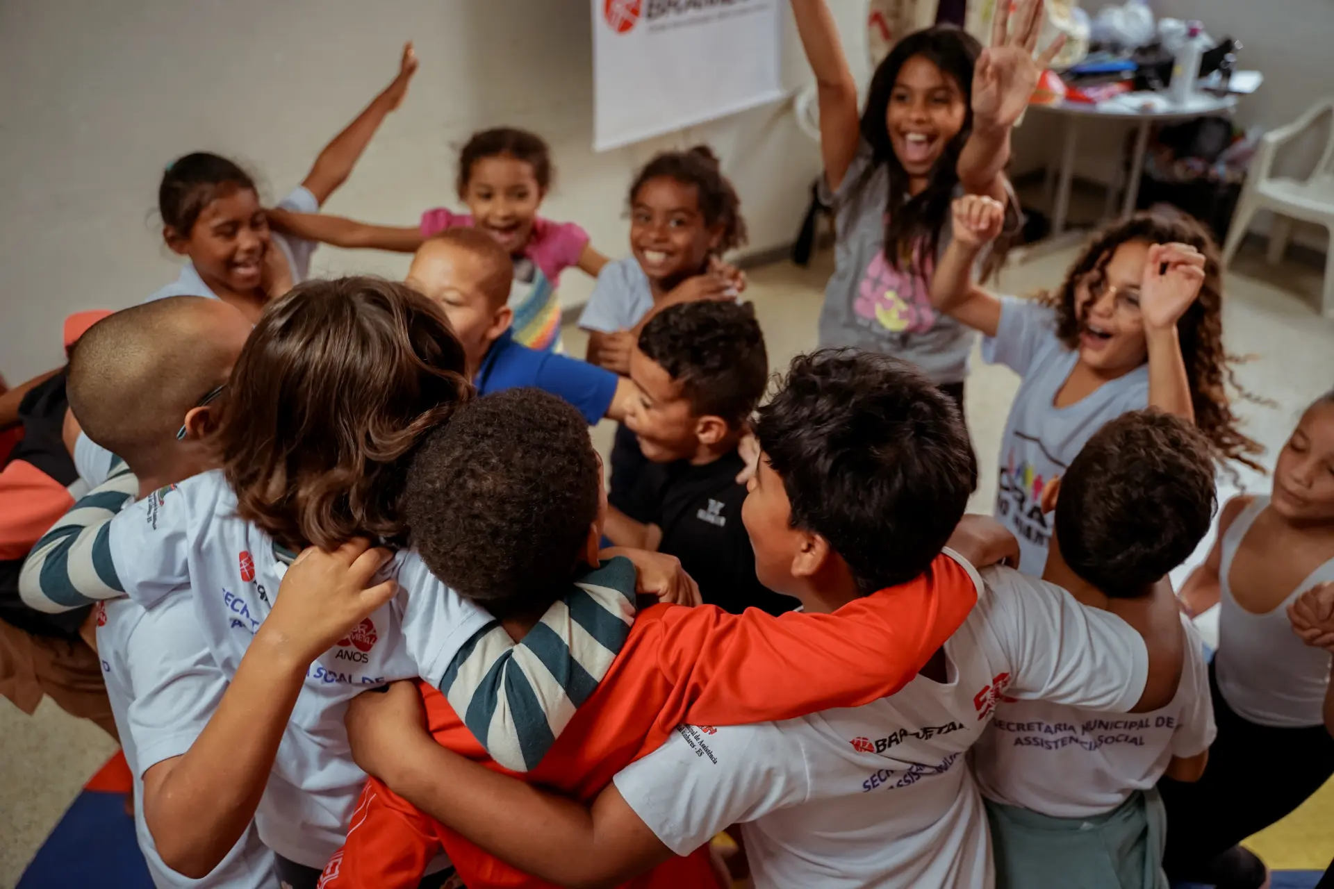 Crianças se abraçando e comemorando em atividade de projeto social