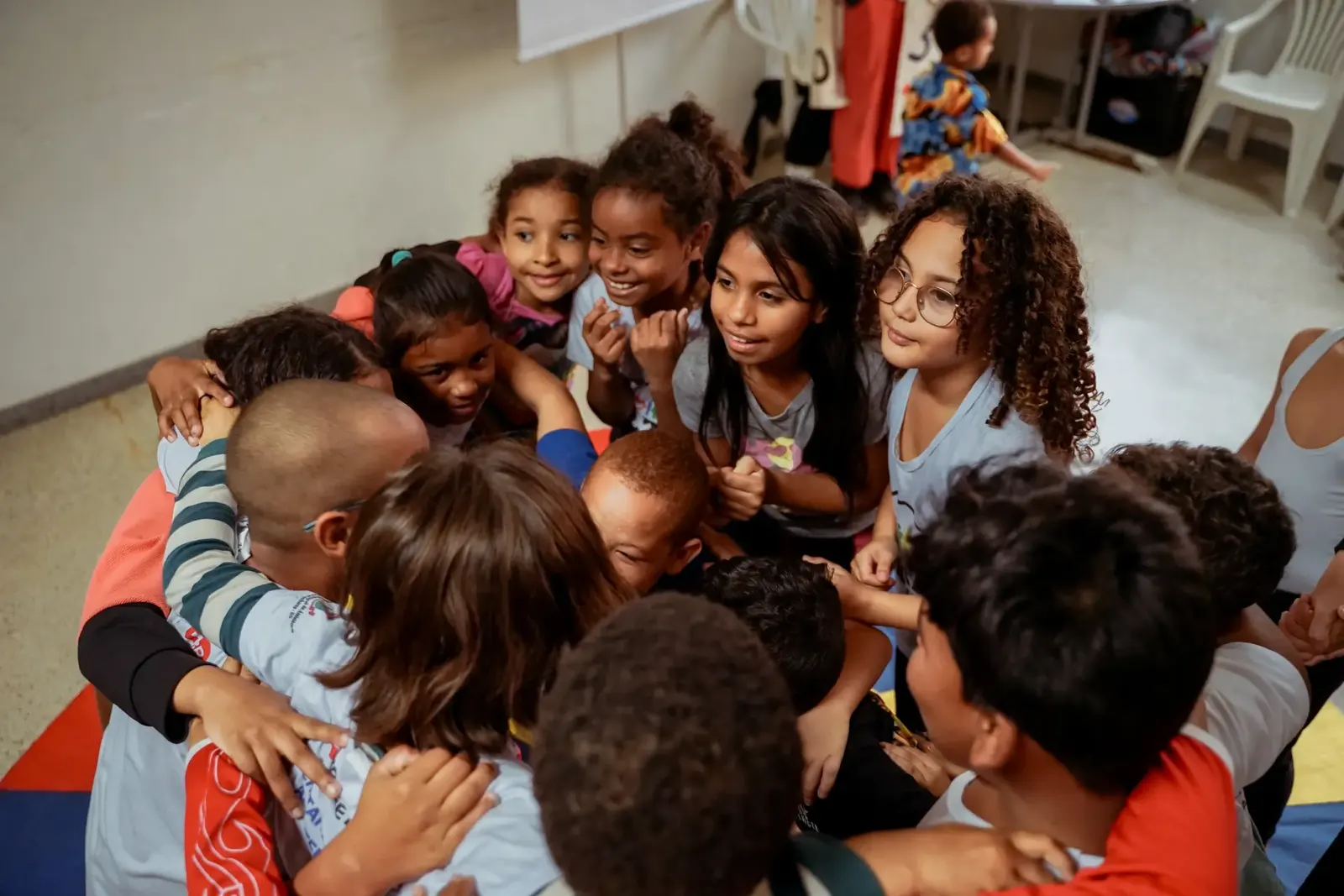 Crianças se abraçando em roda durante atividade do Neurocultura