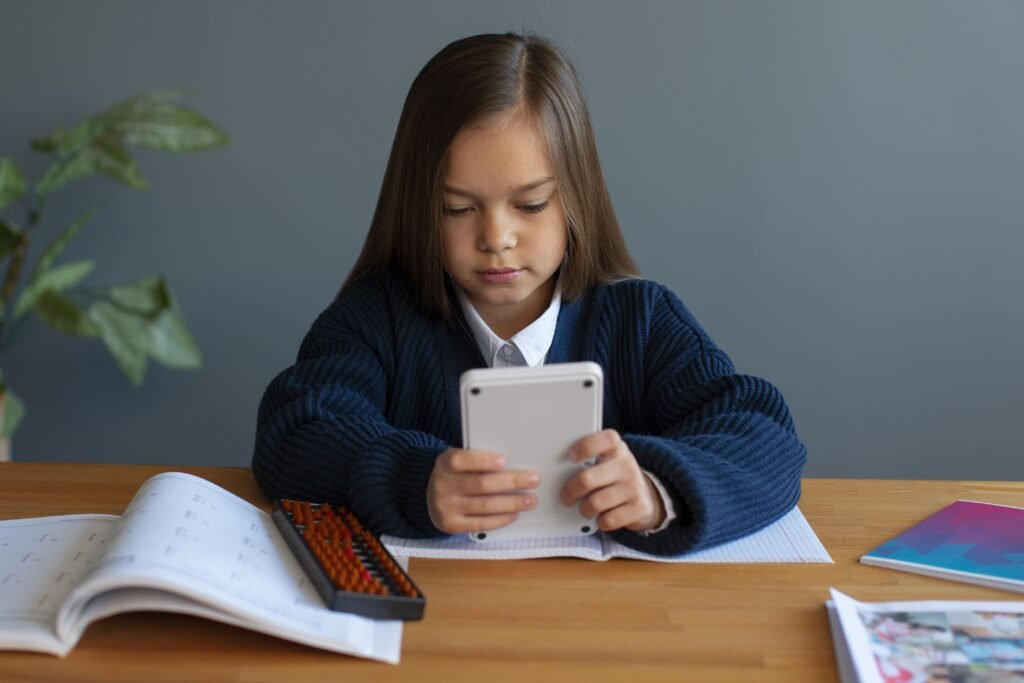 Foto de uma criança mexendo no celular e usando um aplicativo para estudar