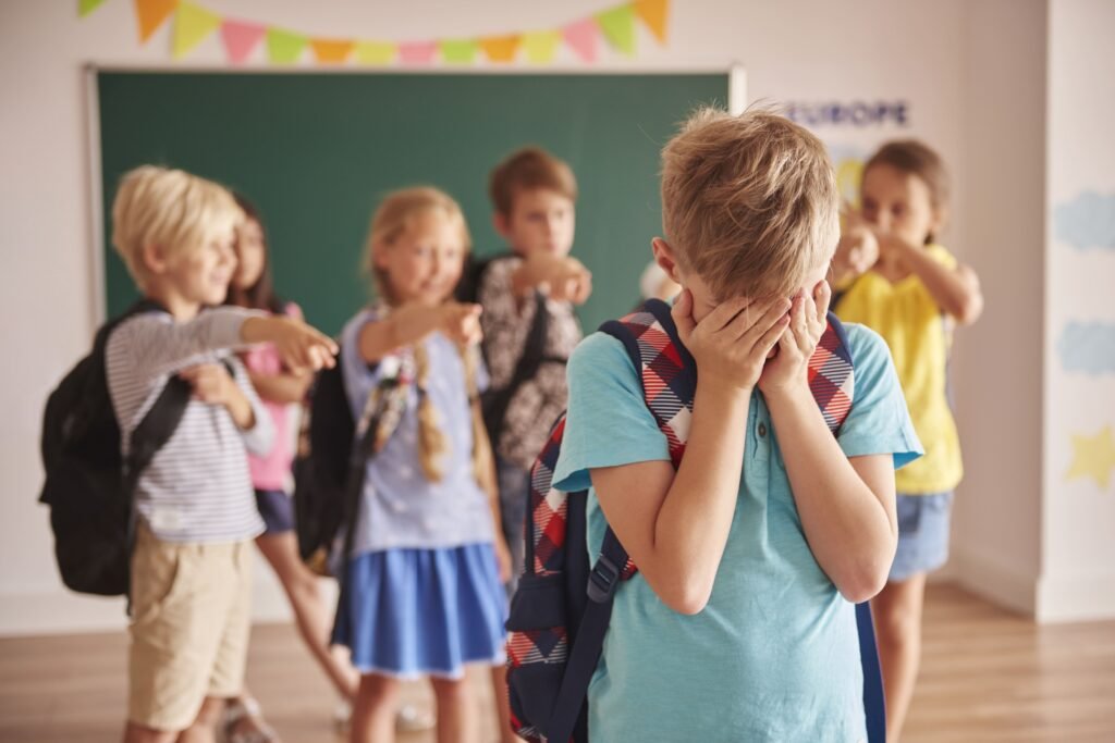 Fotos de crianças rindo de uma outra triste, simulando violência na escola