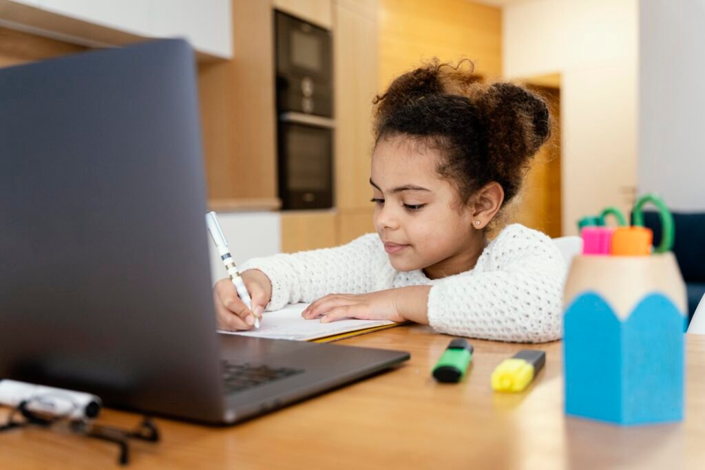 Foto de uma criança estudando no notebook, simulando a Educação 4.0