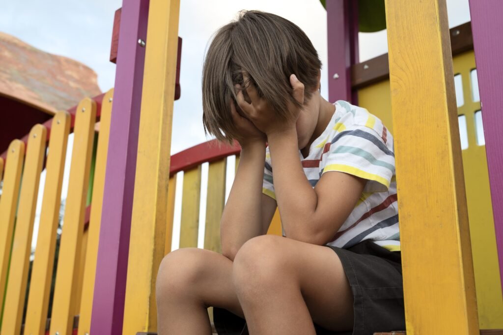 Foto de uma criança triste, simulando uma depressão infantil